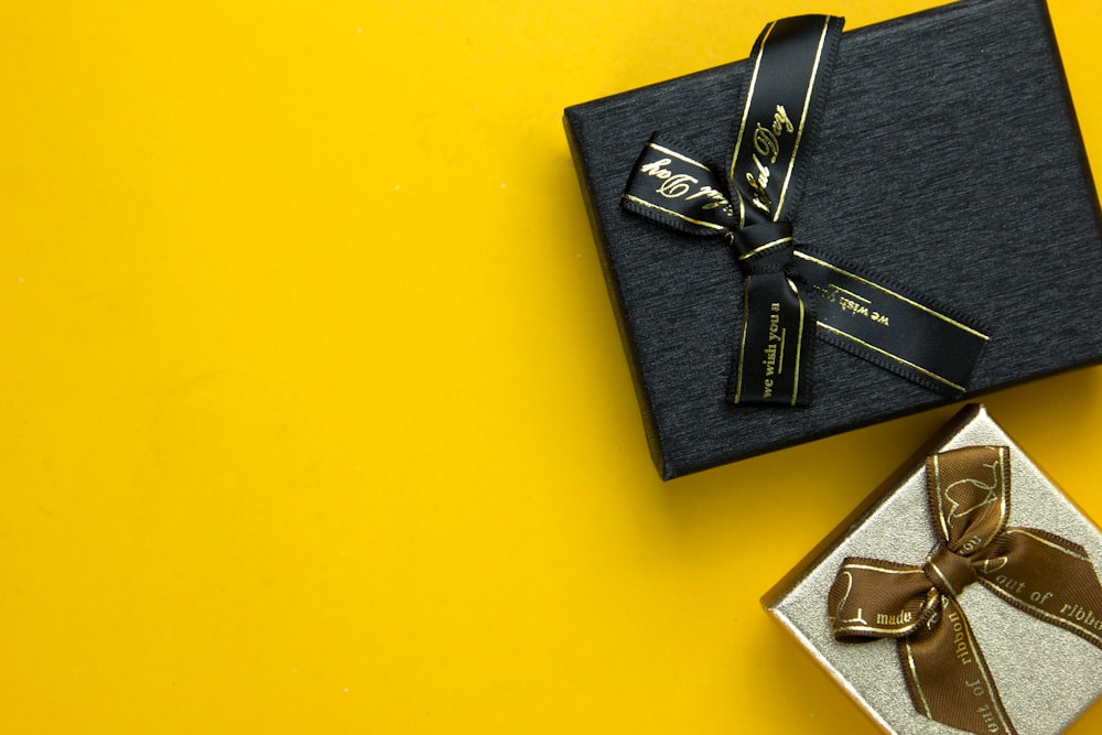 Kotak hadiah hitam dengan pita emas